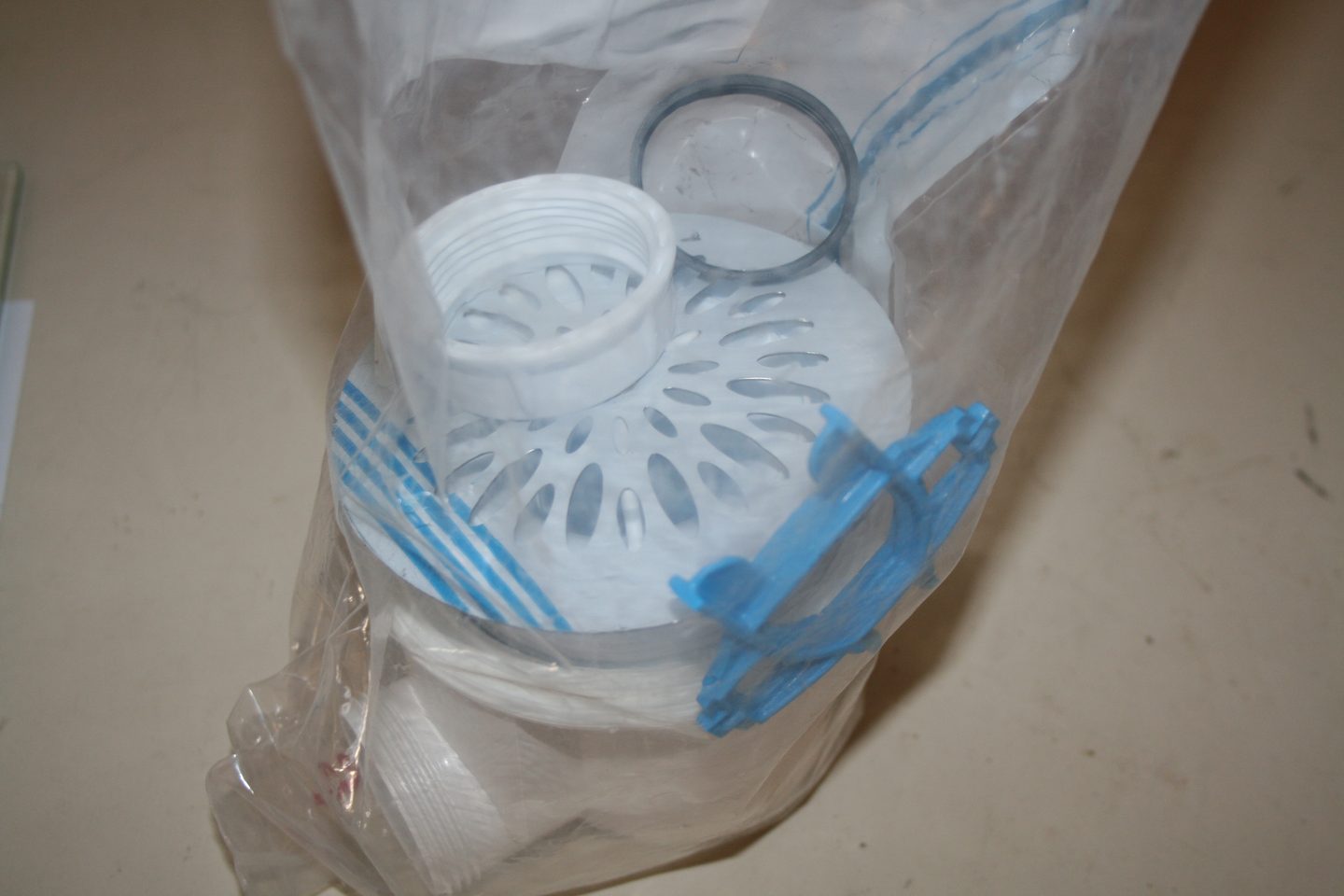 Bonde de douche Nicoll : grille, corps blanc, écrou, joint et clé de serrage