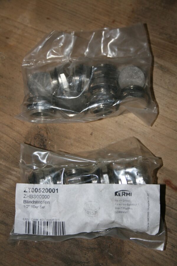 Deux sachets scellés de bouchons obturateurs filetés Kermi 1/2 pouce, référence ZT00520001, posés sur un plan en bois