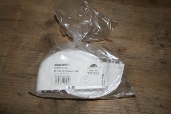 Sachet plastique scellé contenant un cache blanc de pied de radiateur Kermi, réf. ZB00290001, étiquette du fabricant visible