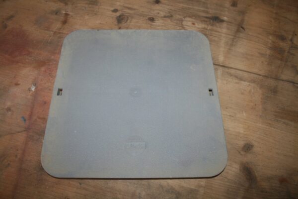 Couvercle carré en PVC gris-bleu Nicoll, logo moulé, posé sur un plancher en bois