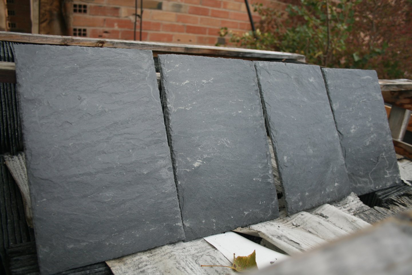 Quatre ardoises naturelles 30 x 20 cm posées debout sur leur palette, face gris foncé