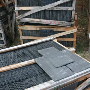 Palettes d'ardoises 50 x 25 cm en caisse bois marquées 50X25, avec ardoises-étiquettes indiquant 1,30 € la pièce et le prix de chaque palette