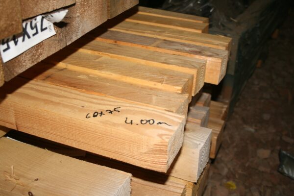 Pile de chevrons en bois clair de 4 m, section 60 x 75 mm notée au marqueur sur la pièce du premier plan